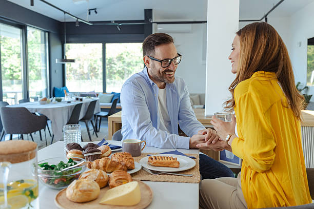 istock Morning breakfast with a loving couple at a bright modern kitchen, sharing smiles and conversation 2246695313