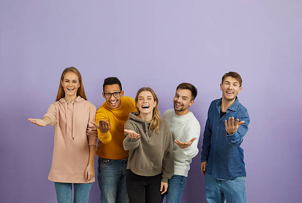 istock Group of happy young people saying 'Come here', smiling and doing an inviting gesture 2246695443