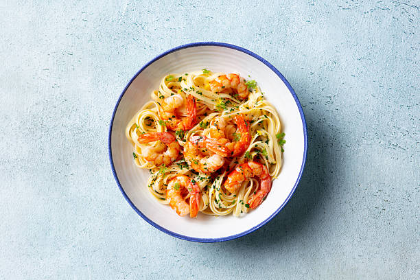 istock Pasta with shrimps and fresh herbs. Light blue background. Top view. 2246700233