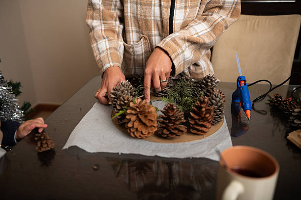 istock Family Decorating Pinecone Wreath With Pine Cones And Greenery At Home 2246701950