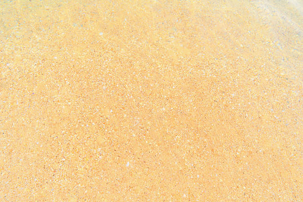 water on spotted sandy sea bottom background