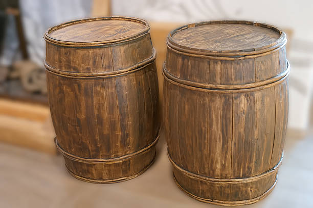 Two rustic wooden barrels are positioned next to each other in an indoor environment, highlighting their craftsmanship and natural finish. They add a warm touch to the decor.