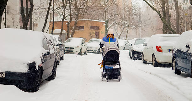 istock Mother navigates baby stroller through heavy snowfall on a winter day 2246704937
