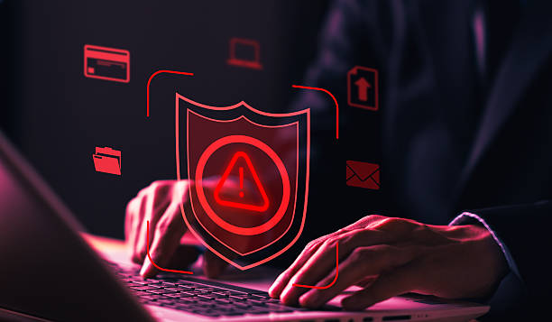 istock Cybersecurity concept with shield alert icon and man working on laptop, representing data protection, system security, cyber attack prevention, and digital defense. 2246706329