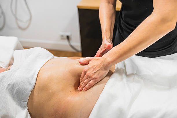 istock Therapist giving deep abdominal massage to client 2246707692