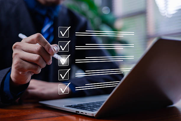 istock Businessman marking a digital checklist on a laptop, representing task management, project planning, productivity, and workflow organization in modern office work and professional business processes. 2246710749