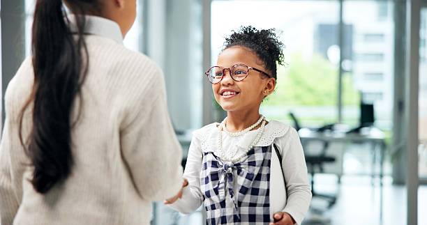 istock Business, children or handshake in office with smile for recruitment, CV document or work costume. Happy girl, kids or shaking hands in workplace with resume for job interview, role play and pretend. 2246715540