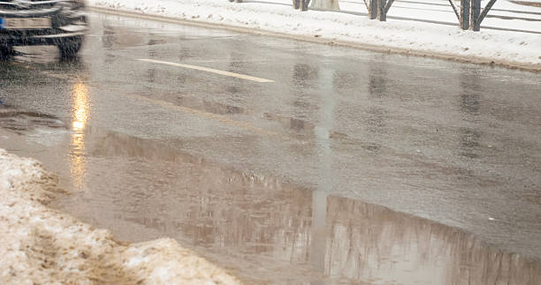 istock Snow falls and melts on city streets during winter months 2246715695