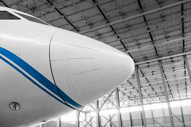 Nose of white aircraft in a hangar.