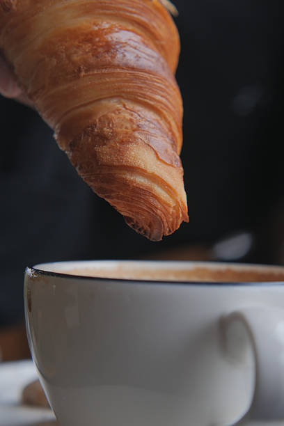 istock Croissant nearing cup of coffee in cozy cafe setting 2246718536