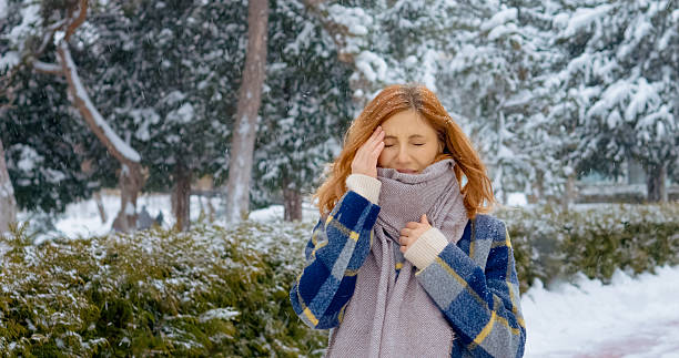 istock Redhead woman experiences headache while walking in snowy park during winter 2246719461