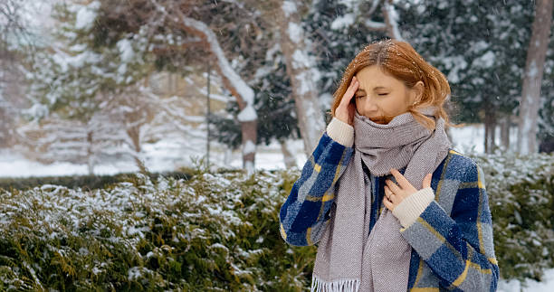 istock Redhead woman struggles with headache during snowy park walk in winter 2246719603