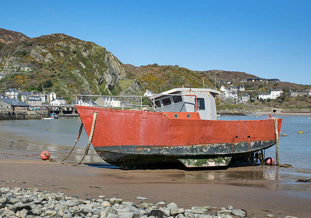 Old rusting fishing boat at low tide at Barmouth West Wales