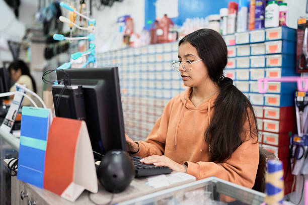 istock Young woman concentrating, working on computer in retail store 2246721532