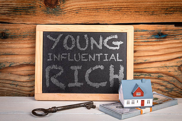 istock Young Influential Rich. Wealth and Success Concept with Chalkboard and Model House 2246722173