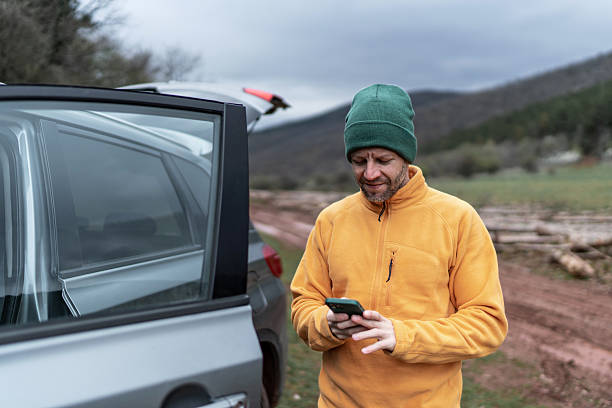 istock Man checking phone for navigation on rural road trip 2246722183