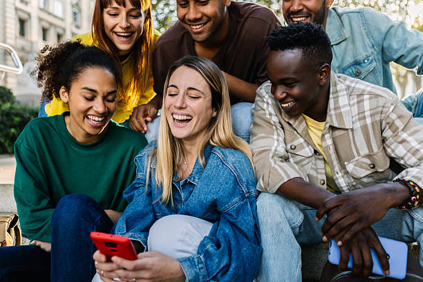 istock Multiracial young people having fun watching social media content on phone 2246722218