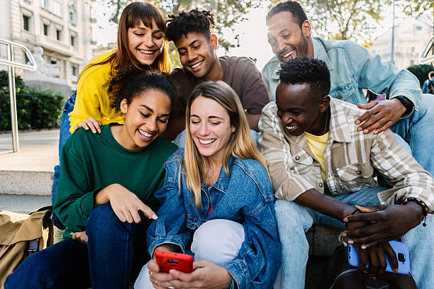 istock Multiracial young people having fun watching social media content on phone 2246722247