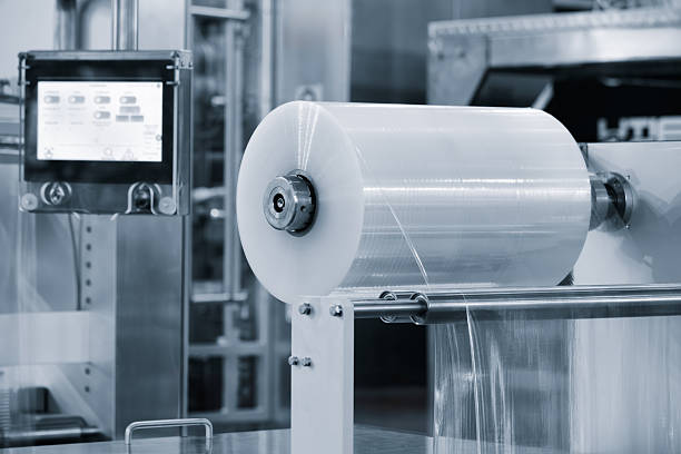 istock Automatic polyethylene plastic bag production machine with lighting effect. Close-up of the roller of the plastic bag production machine in the light blue scene. product packaging concept 2246724537