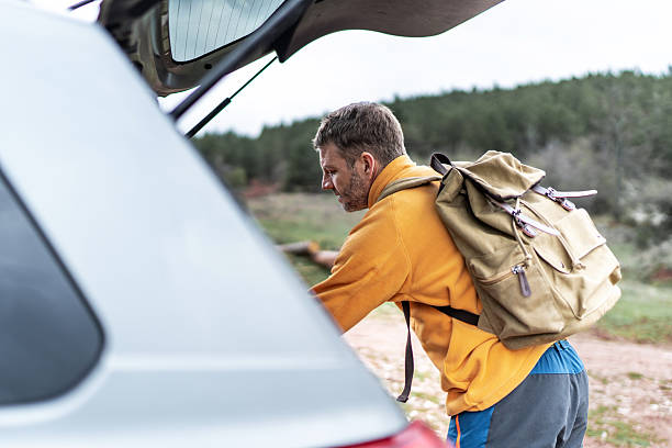 istock Man hiker preparing backpack for journey in nature 2246724562