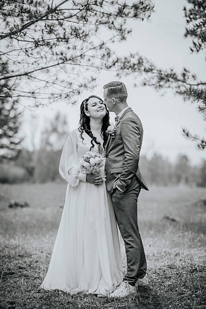 istock Bride and groom in elegant attire share a romantic moment outdoors, surrounded by nature, capturing the essence of love and commitment in a beautiful setting 2246727928