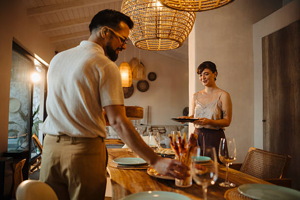 istock Couple Setting Up Dinner Table and Waiting for Friends 2246731358