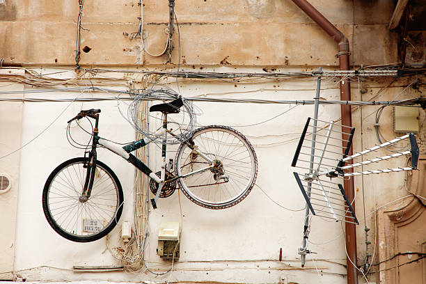 Valencia, Spain - October 9, 2023: Bicycle hooked to pole with missing rear wheel. Most likely the owner left it there and took the wheel to fix a flat tire