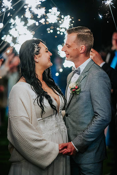 istock Bride and groom smiling at each other, surrounded by sparkling lights, celebrating their wedding night, capturing a moment of joy and love in an enchanting atmosphere 2246732969