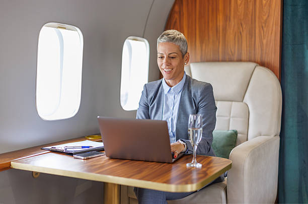 istock Businesswoman flying private jet working on laptop 2246733600
