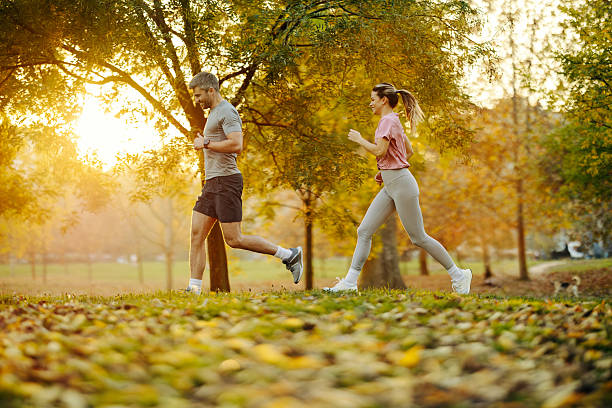 istock Couple jogging in park enjoying autumn workout 2246734848
