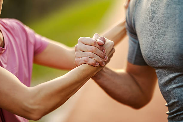 istock Two people clasping forearms showing support and helping 2246734953