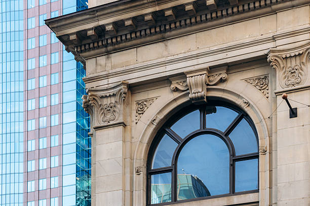 istock Historic arched window with sculpted stone details on heritage building, modern downtown glass skyscraper in background, Ville-Marie 2246738162