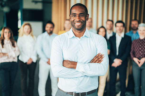 istock Confident business leader standing with team in office 2246738535