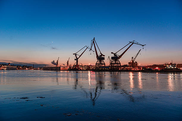 istock Industrial harbor cranes reflecting in evening water.. 2246740004