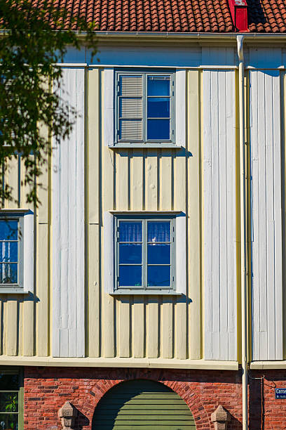 Windows on tall residential building with vertical wood panels.