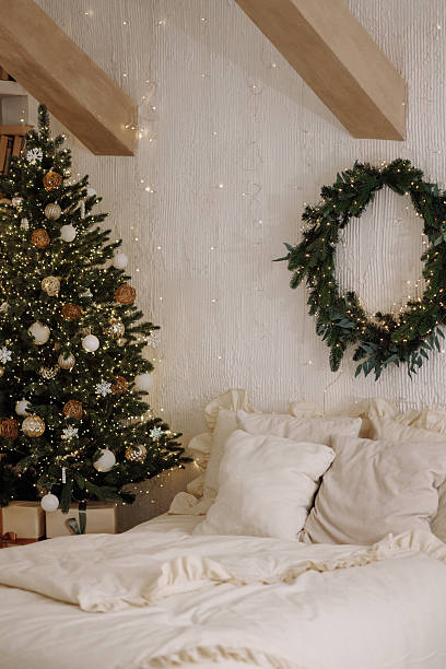 istock Scandi loft bedroom with Christmas tree and wreath on white textured wall 2246743288