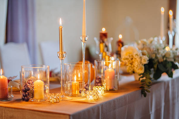 istock Elegant table setting adorned with candles, glass holders, and floral arrangements, creating a warm ambiance for a special occasion or celebration with soft lighting 2246743583