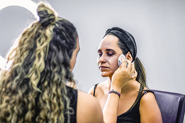 Makeup artist applying foundation on woman's face