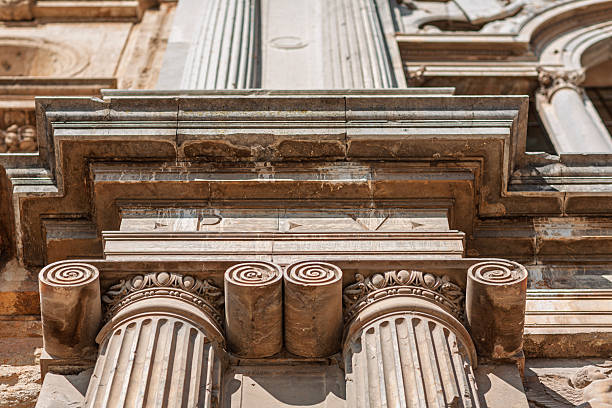 Close-up view of the Ionic volutes and cornice on the Palace of Charles V, showcasing intricate Renaissance carvings in Granada, Andalusia, Spain.