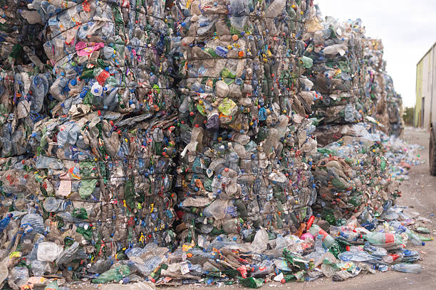 istock Stacks of tightly packed bales made from compressed plastic waste are lined up outdoors at a recycling facility 2246755614