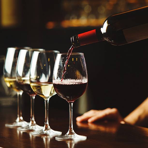 istock Red wine being poured into a glass on a bar counter 2246759372