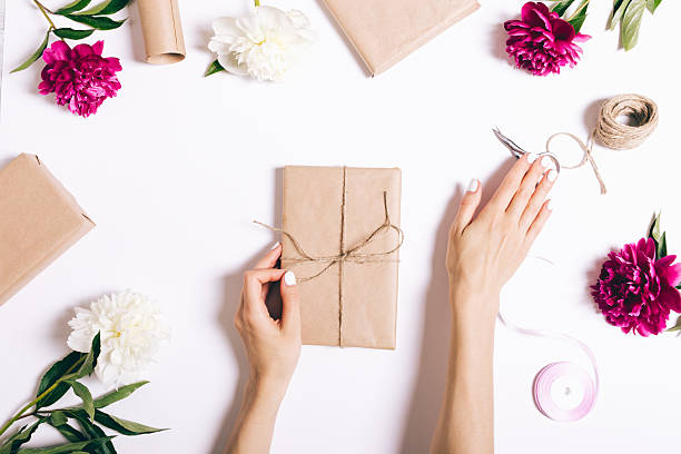 istock Woman is wrapping a gift with a ribbon and a bow 2246761572