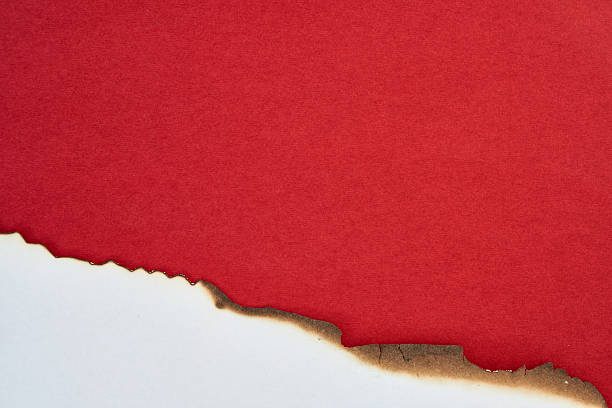 istock Torn red paper revealing a textured white background with a burnt edge 2246765574