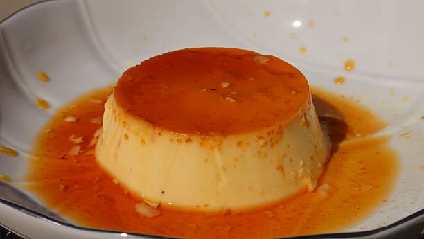 Part 1: A Side View Delightful Dessert Moment Featuring a Small Caramel Pudding With a Shiny Orange Caramel Top.