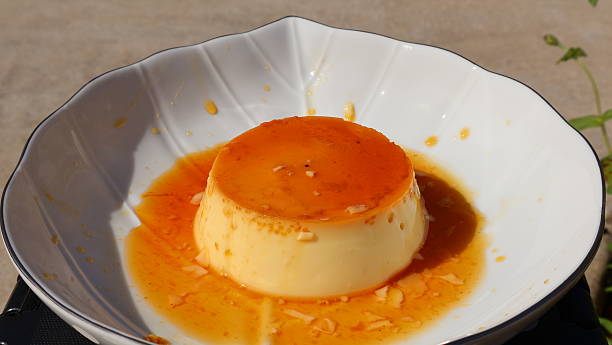 istock Part 2: Minimalist Dessert Shot Featuring a Mini Caramel Pudding on a Leaf-Shaped White Plate. 2246765903