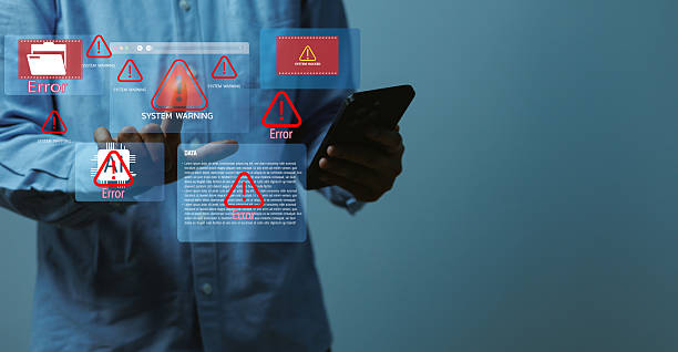 istock Businessman standing holding smartphone with virtual error icons and warning signs, representing cybersecurity threats, system malfunction, data protection, and technology risk management concept 2246769374