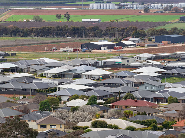 istock Suburban rooftops close together with farm land in background 2246774048