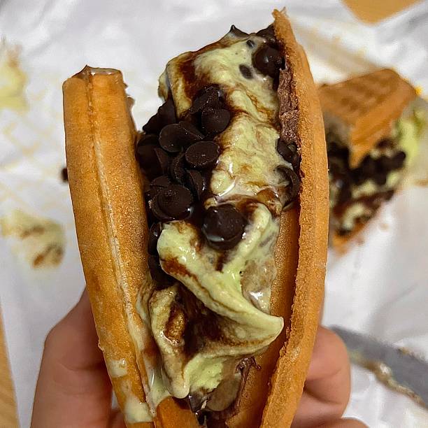 Crispy, golden waffles topped with creamy ice cream, creating a perfect balance of warm and cold, crunchy and smooth. A delightful dessert or breakfast treat, with toppings like fruits or syrup.
