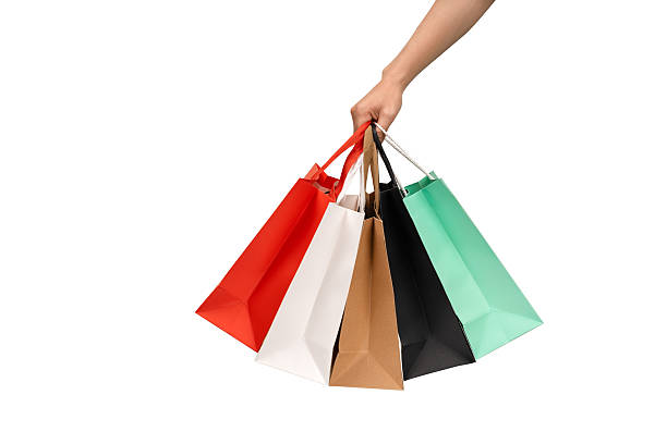 istock A person's hand holding a paper shopping bag with handles on a clean white background. Studio shot with ample copy space for text, logos, or branding. Isolated on white, cut out. 2246781676