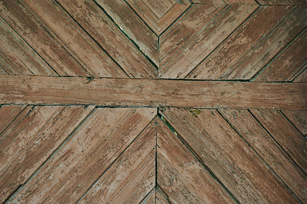 Wooden brown boards with old paint particles, fragment of house wall. For background, posters, banners, design.